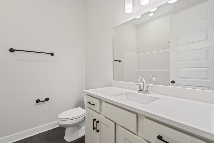 Bathroom featuring a white vanity with recessed panel cabinetry and matte black hardware, a rectangular undermount sink, and a single-handle chrome faucet Bathroom featuring a white vanity with recessed panel cabinetry and matte black hardware, a rectangular undermount sink, and a single-handle chrome faucet