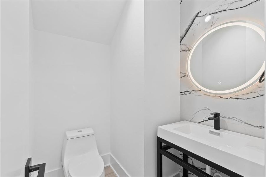 Chic ground-floor powder room with a striking marble accent wall.