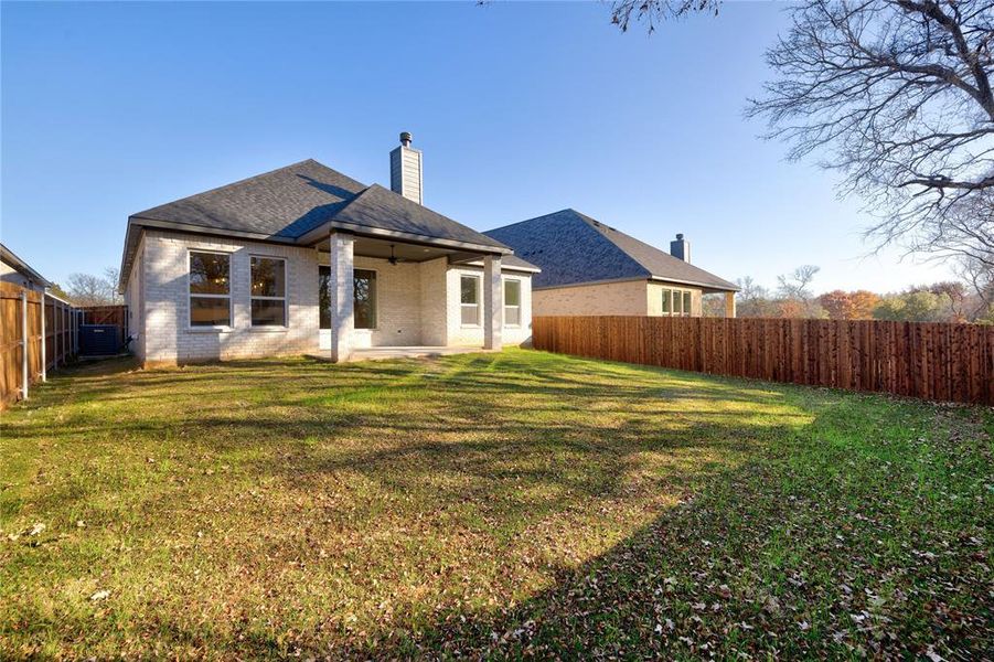 Rear view of property featuring ceiling fan, a yard, a patio, and central air condition unit