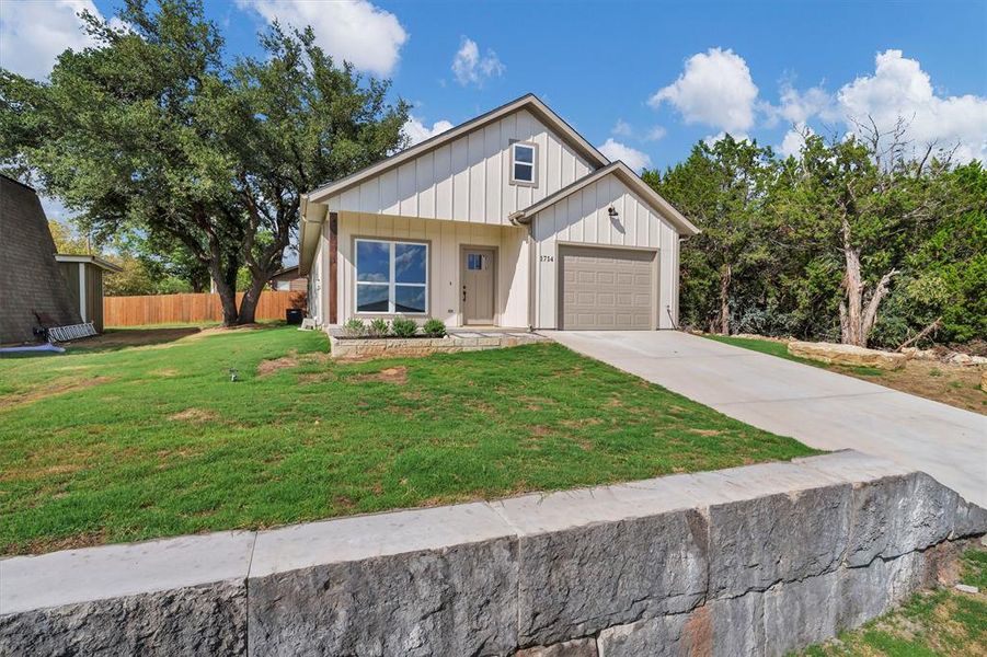 Modern inspired farmhouse with board and batten siding, concrete driveway, and a porch Modern inspired farmhouse with board and batten siding, concrete driveway, and a porch