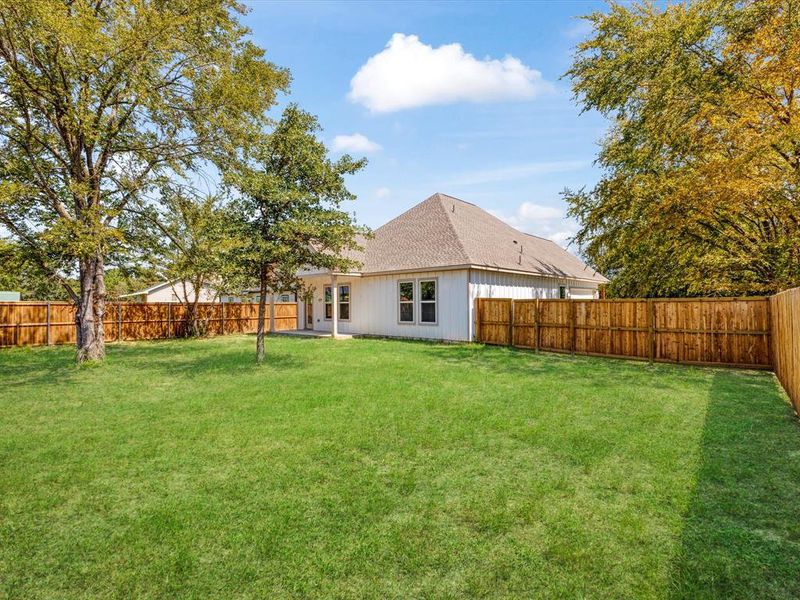 Back of property with a patio, a fenced backyard, and a shingled roof Back of property with a patio, a fenced backyard, and a shingled roof
