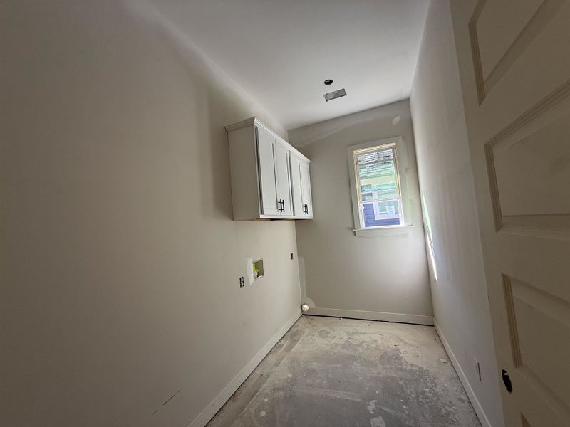 Laundry room featuring cabinet space, washer hookup, concrete flooring, and electric dryer hookup