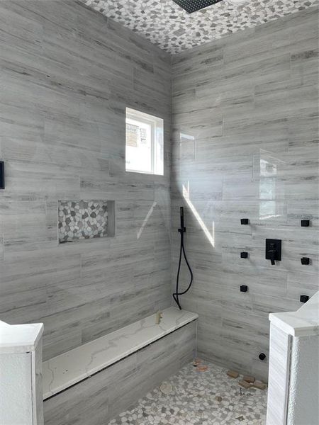 Double shower with tiled walls and pebble tile ceiling