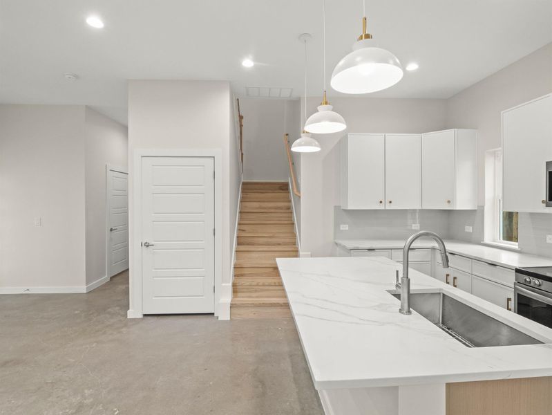 Kitchen featuring an island with a stainless steel sink and a gooseneck faucet