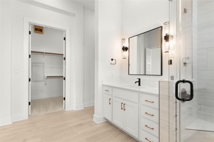 Full bath with vanity, wood finished floors, and a stall shower Full bath with vanity, wood finished floors, and a stall shower
