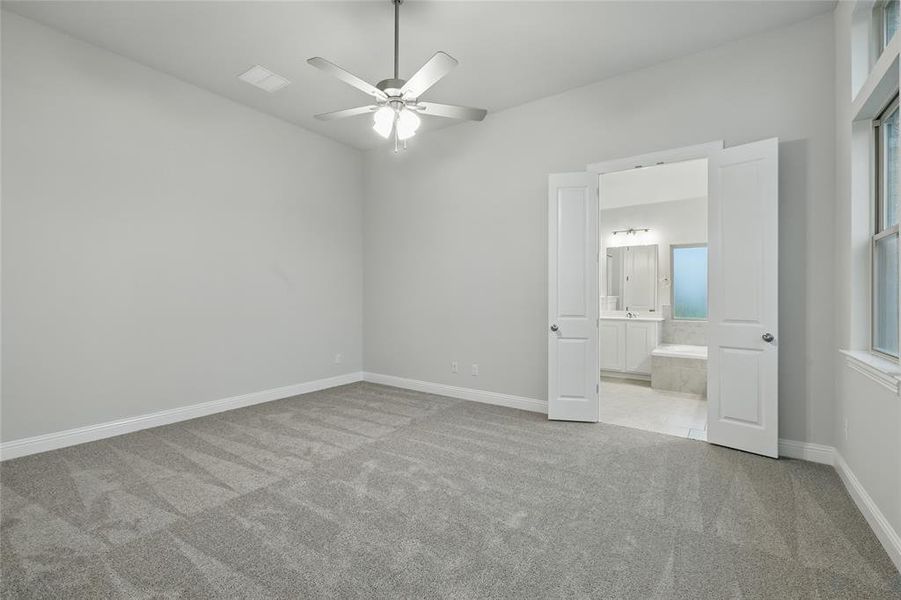 Unfurnished bedroom with light carpet and ceiling fan Unfurnished bedroom with light carpet and ceiling fan