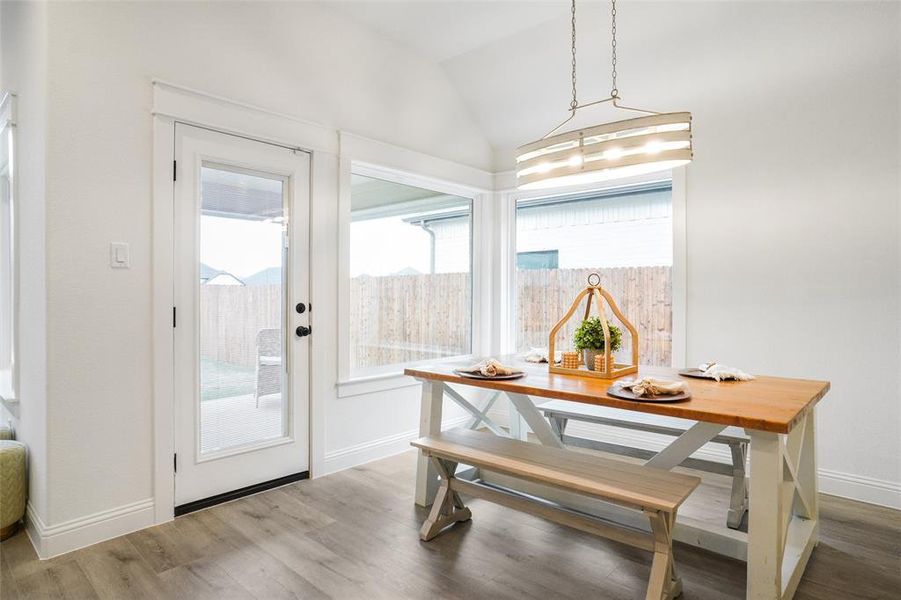 Dining room with hardwood / wood-style flooring and lofted ceiling