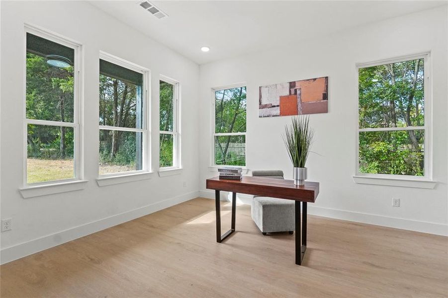 Unfurnished office featuring light wood finished floors, plenty of natural light, and recessed lighting Unfurnished office featuring light wood finished floors, plenty of natural light, and recessed lighting