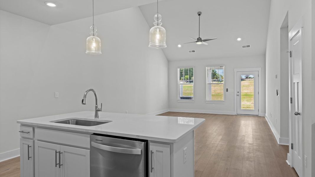 Highly skilled craftsmanship shines in this modern kitchen with pendant lighting and a central island focal point Highly skilled craftsmanship shines in this modern kitchen with pendant lighting and a central island focal point