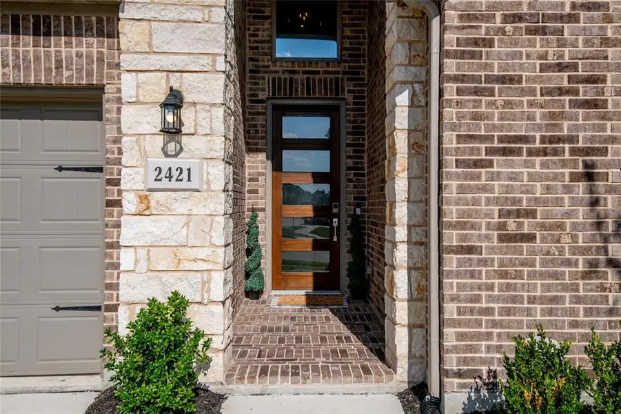 An impressive covered entry and modern glass-panel front door create a warm welcome, setting the stage for the luxury and thoughtful design found throughout this exceptional home. An impressive covered entry and modern glass-panel front door create a warm welcome, setting the stage for the luxury and thoughtful design found throughout this exceptional home.
