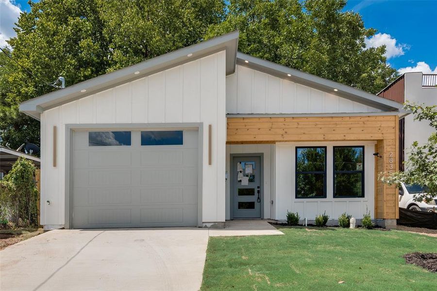 View of front facade with a garage and a front lawn