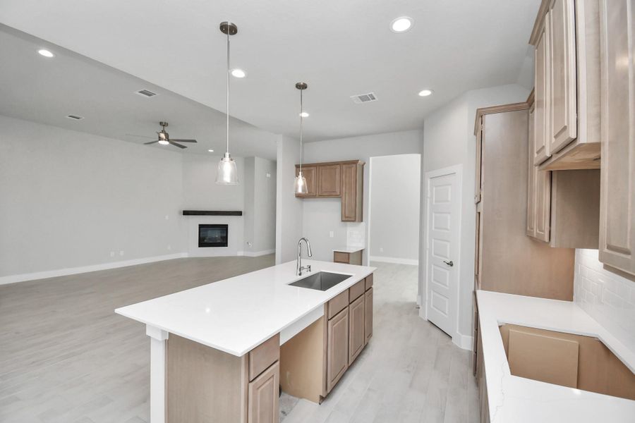 The kitchen is a culinary haven, featuring granite countertops, a tile backsplash, stainless steel appliances, 42” upper cabinets, and undercabinet lighting. Sample photo of completed home with similar floor plan. Actual colors and selections may vary.