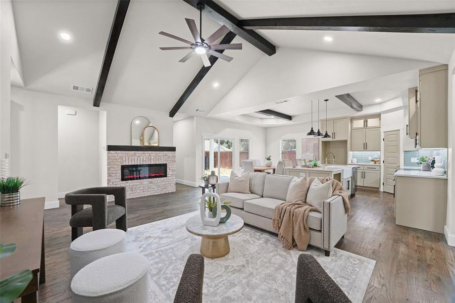 Vaulted ceilings with exposed beams, wood-finish flooring, and a contemporary fireplace with brick surround Vaulted ceilings with exposed beams, wood-finish flooring, and a contemporary fireplace with brick surround
