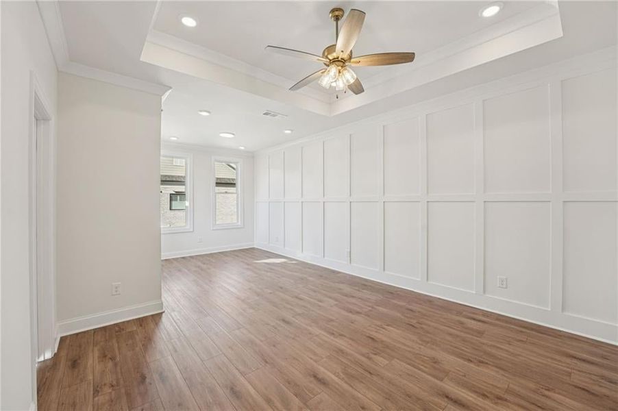 Spare room featuring a tray ceiling, recessed lighting, wood finished floors, ceiling fan, and ornamental molding Spare room featuring a tray ceiling, recessed lighting, wood finished floors, ceiling fan, and ornamental molding