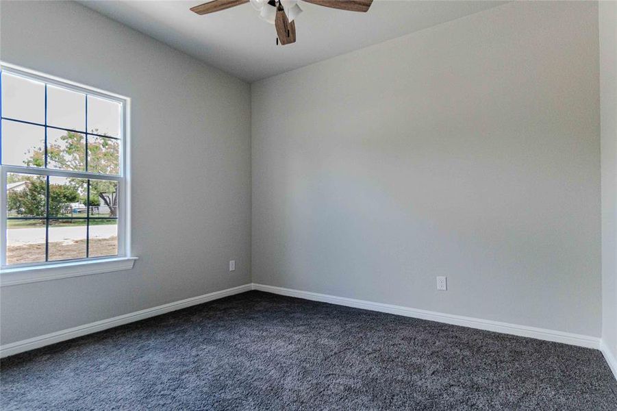 Unfurnished room featuring carpet flooring and ceiling fan