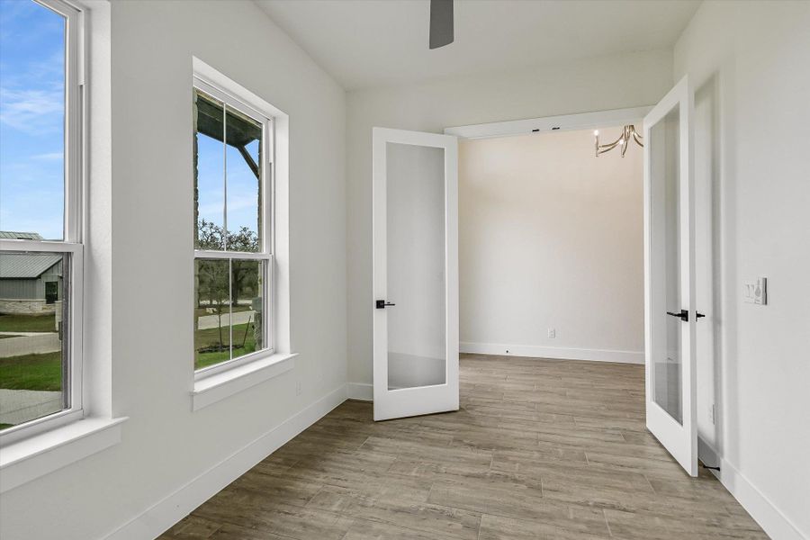 Unfurnished bedroom with french doors, light wood-style floors, and a ceiling fan