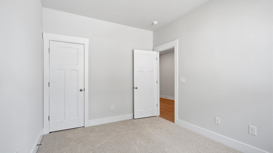 Accomplished design shines in this carpeted guest bedroom with a functional walk-in closet at Clarke Townes Accomplished design shines in this carpeted guest bedroom with a functional walk-in closet at Clarke Townes