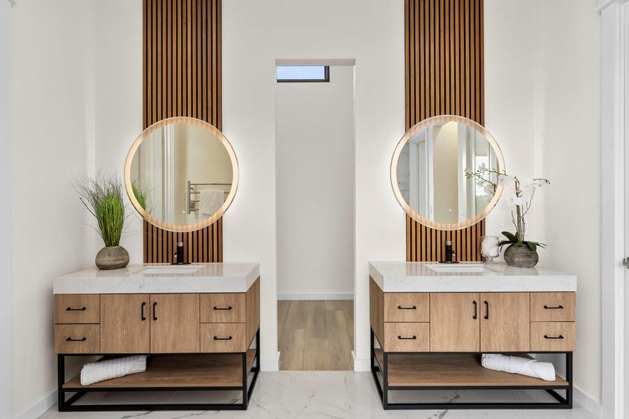 Full bathroom with two vanities and light marble finish floors