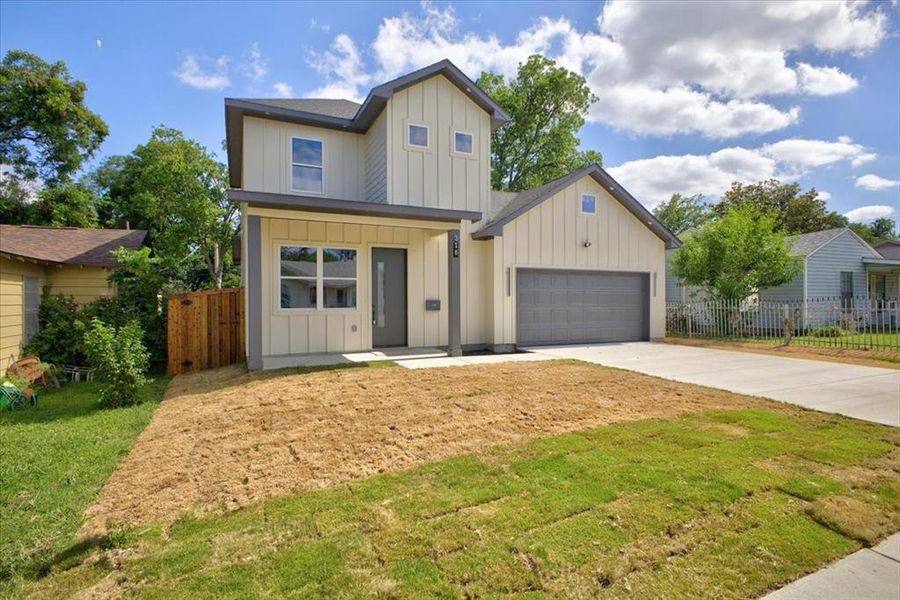 Contemporary two-story residence featuring a striking light-colored vertical siding exterior with dark trim accents Contemporary two-story residence featuring a striking light-colored vertical siding exterior with dark trim accents