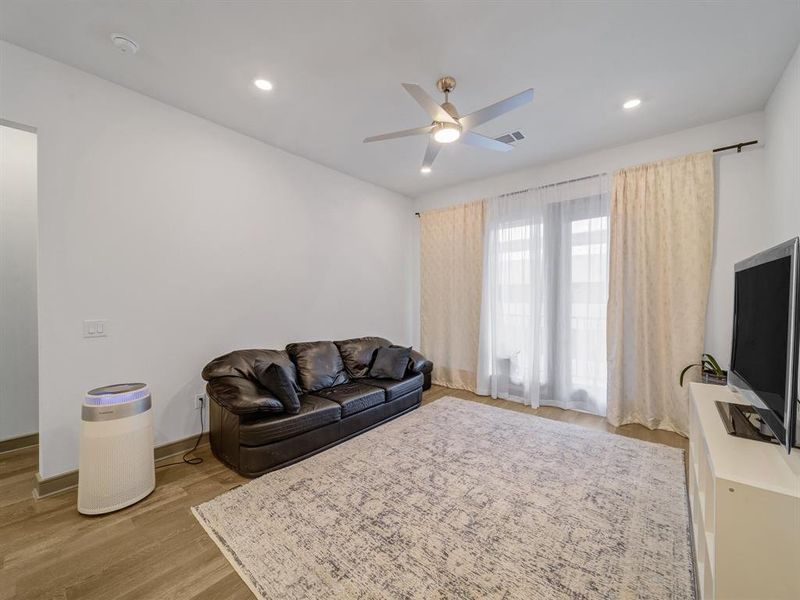 Living area featuring light wood-style floors, a ceiling fan, and recessed lighting