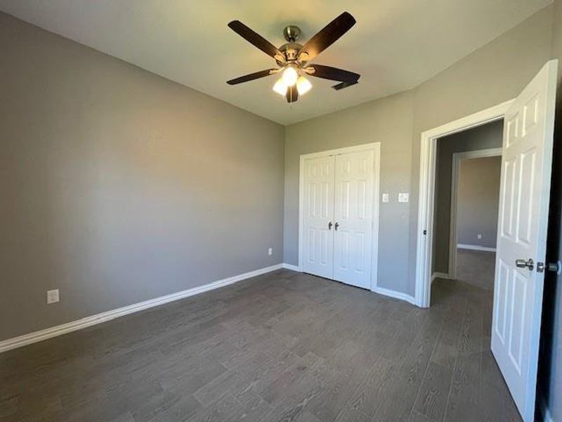 2nd bedroom featuring a ceiling fan, baseboards, wood-style finished floors, and a closet 2nd bedroom featuring a ceiling fan, baseboards, wood-style finished floors, and a closet