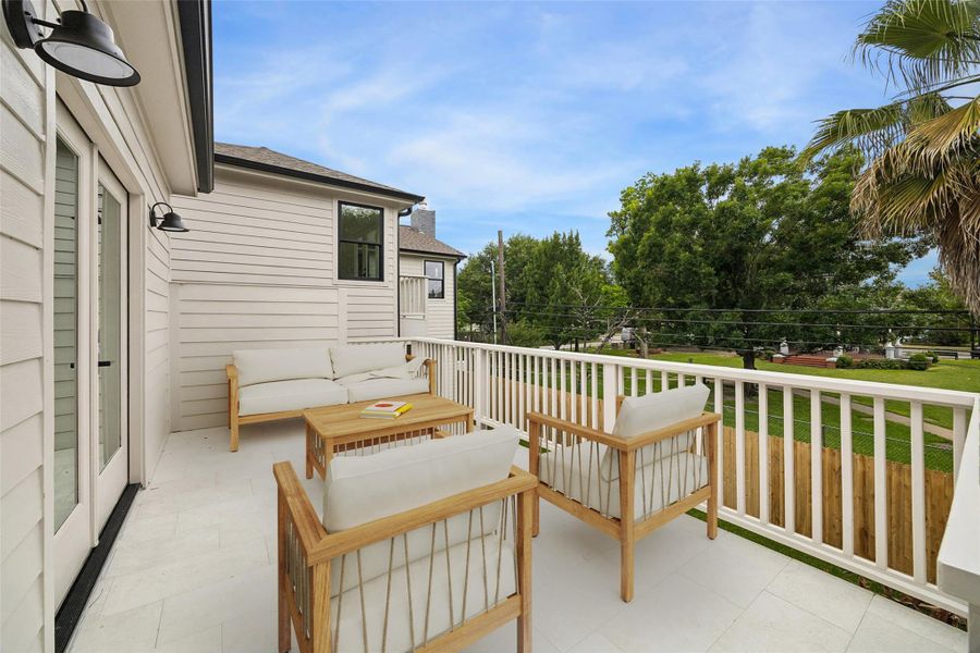The elevated terrace extends the garage apartment living space outdoors with room for seating, entertaining, or quiet mornings overlooking the surrounding treetops. Positioned beside Marmion Park, the setting offers a rare sense of openness within the Heights. (digitally staged)