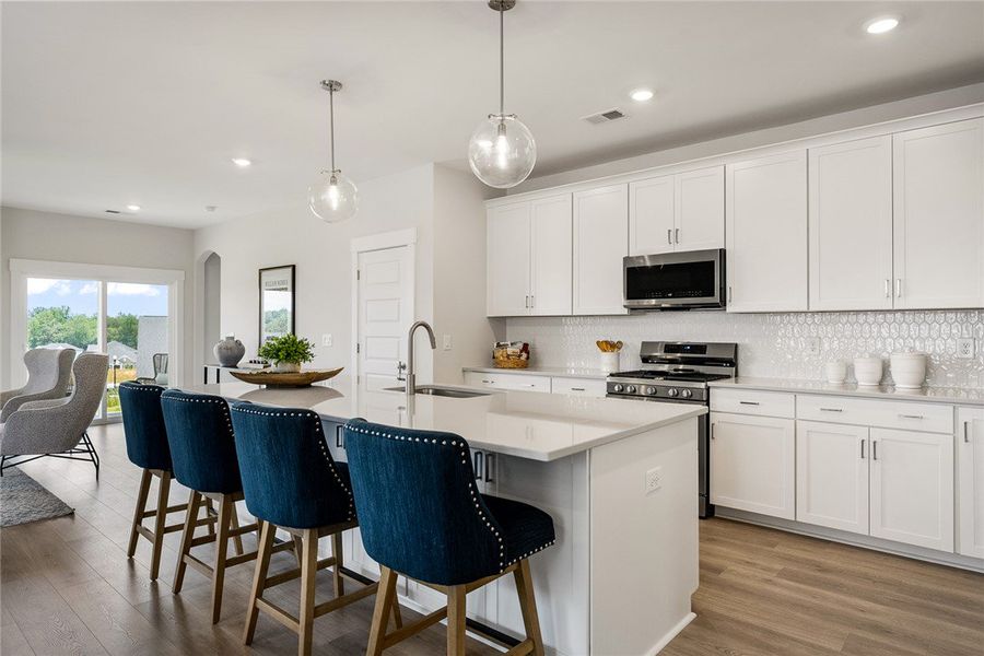 A sleek island kitchen with crisp white cabinetry A sleek island kitchen with crisp white cabinetry