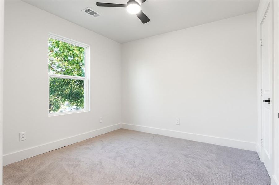 Carpeted spare room featuring baseboards and ceiling fan