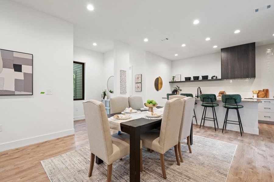 Dining space with recessed lighting and light wood-type flooring