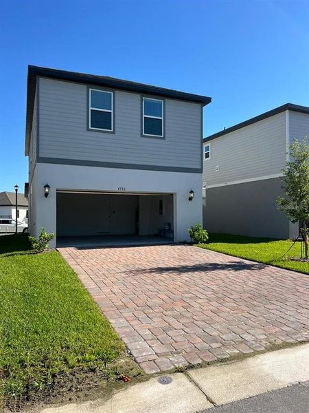 Front exterior of a new home in The Meadow at Crossprairie Bungalows, St. Cloud, FL, highlighting curb appeal (Image 1).