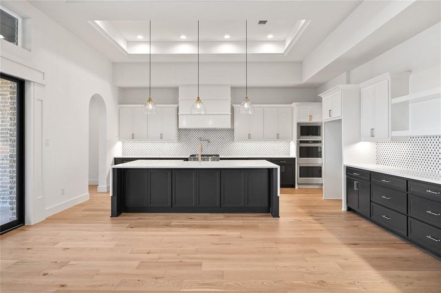 Kitchen featuring dark cabinetry, decorative light fixtures, white cabinetry, backsplash, and recessed lighting Kitchen featuring dark cabinetry, decorative light fixtures, white cabinetry, backsplash, and recessed lighting