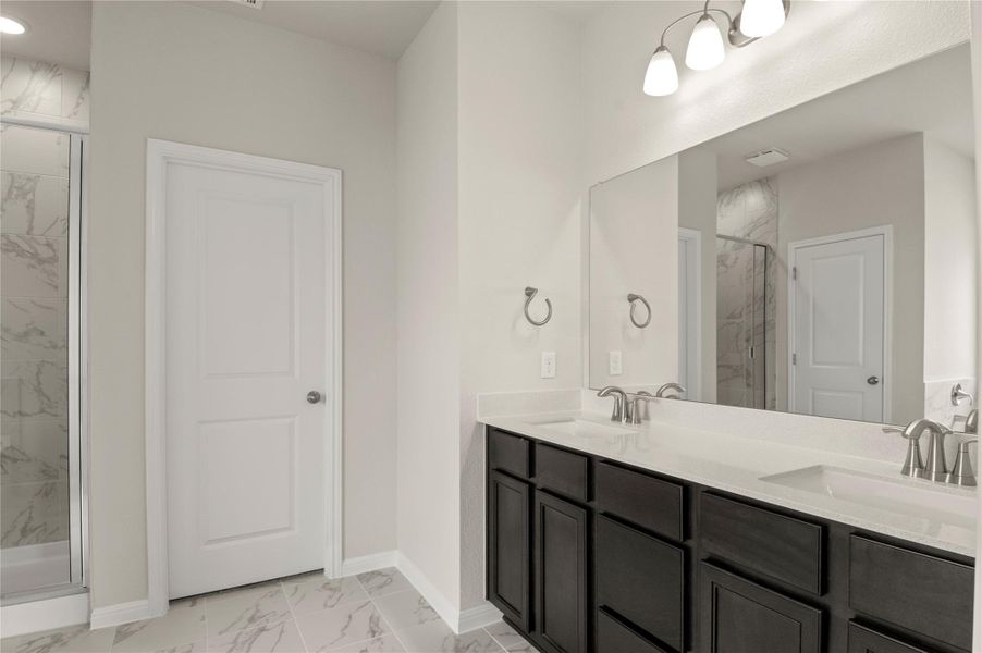 Full bathroom with marble finish floors, a marble finish shower, double vanity, and recessed lighting