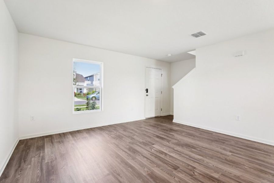 A room with a wood floor and a painting on the wall.