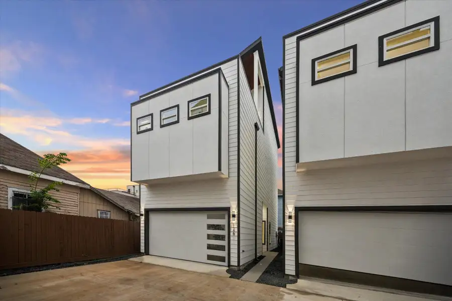Modern, minimalist two-story home with a clean white facade and black trim. Features large windows and a spacious garage. The property is set against a beautiful sunset, enhancing its contemporary design. Modern, minimalist two-story home with a clean white facade and black trim. Features large windows and a spacious garage. The property is set against a beautiful sunset, enhancing its contemporary design.