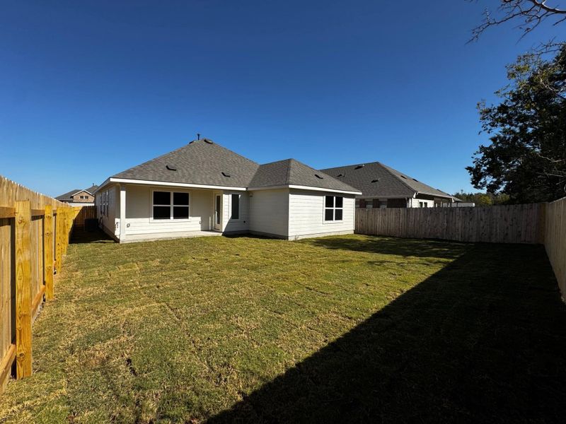 Rear view of property with a patio, a fenced backyard, and roof with shingles