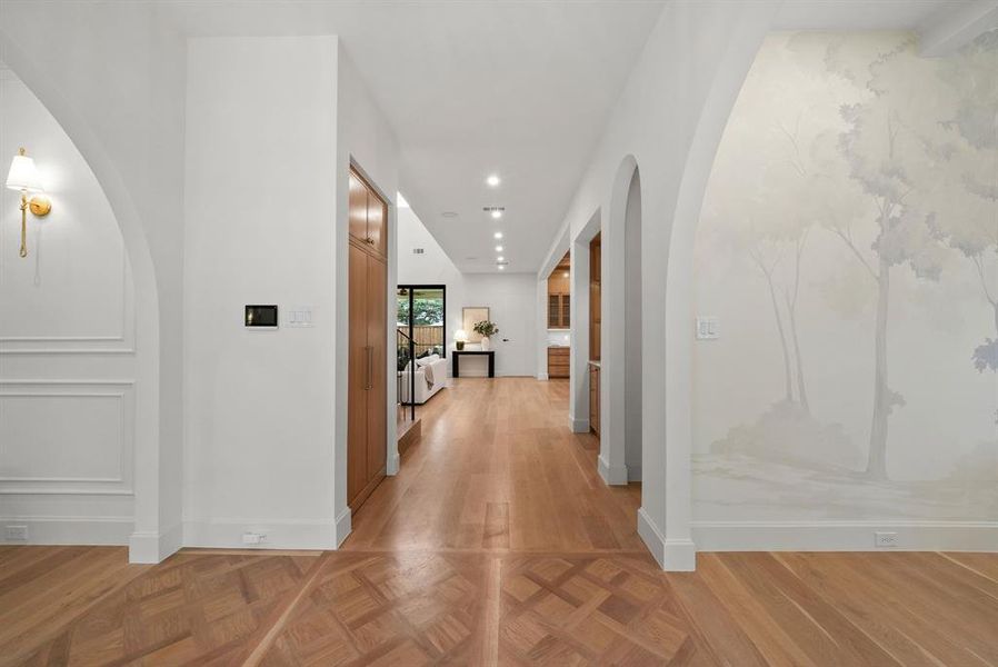 Hall with arched walkways, parquet flooring, and recessed lighting Hall with arched walkways, parquet flooring, and recessed lighting