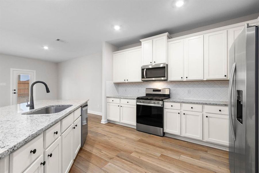 The beautiful kitchen with granite countertops and Whirlpool kitchen appliances.