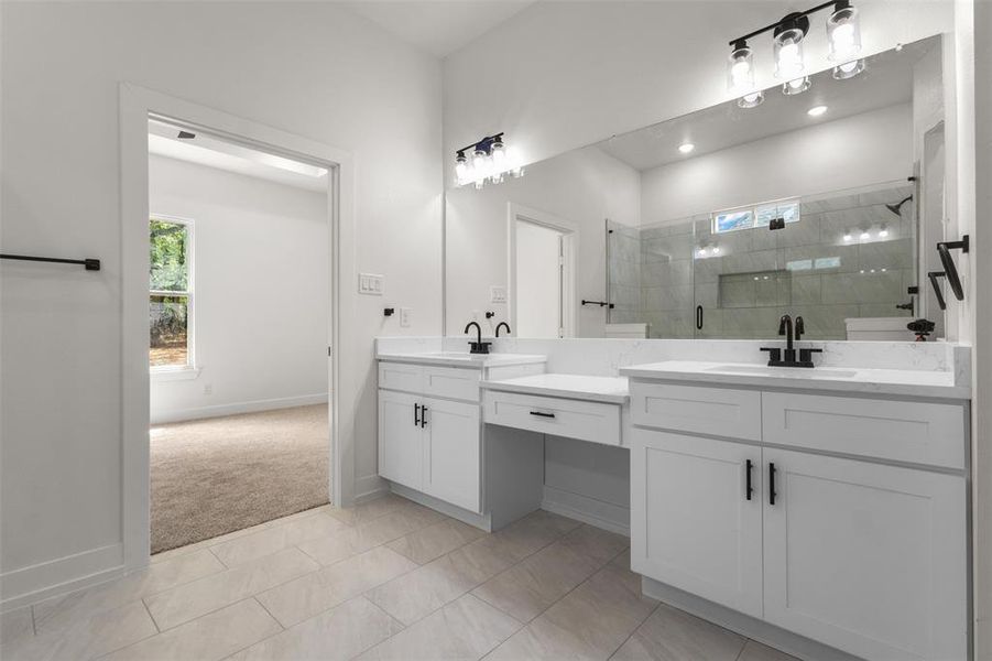 Bathroom featuring dual vanity with white cabinetry, quartz countertops, and matte black fixtures
