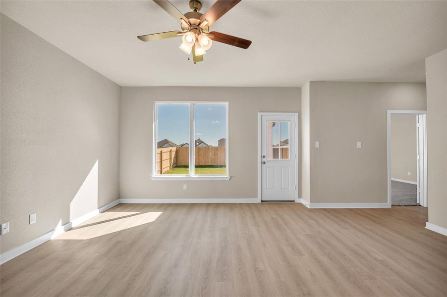 Unfurnished living room featuring light wood finished floors and a ceiling fan