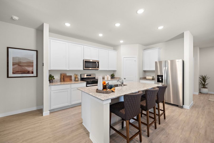 A kitchen with white cabinets.