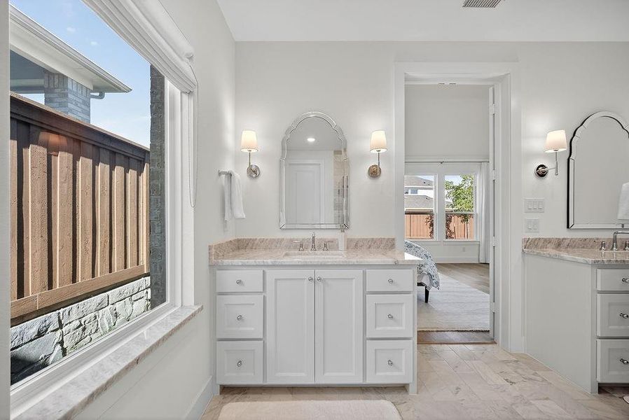 Bathroom featuring two vanities and light wood-style floors Bathroom featuring two vanities and light wood-style floors