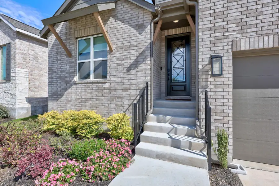 Entrance to property featuring brick siding and a garage