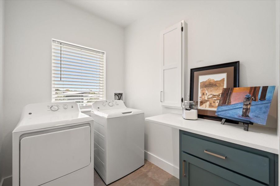 Light Bright Laundry area with custom built in for your ironing board, custom cabinet with slide outdrawers