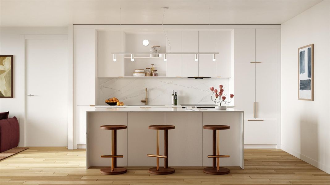 A minimalist kitchen with light wood, quartz countertops, and modern appliances.