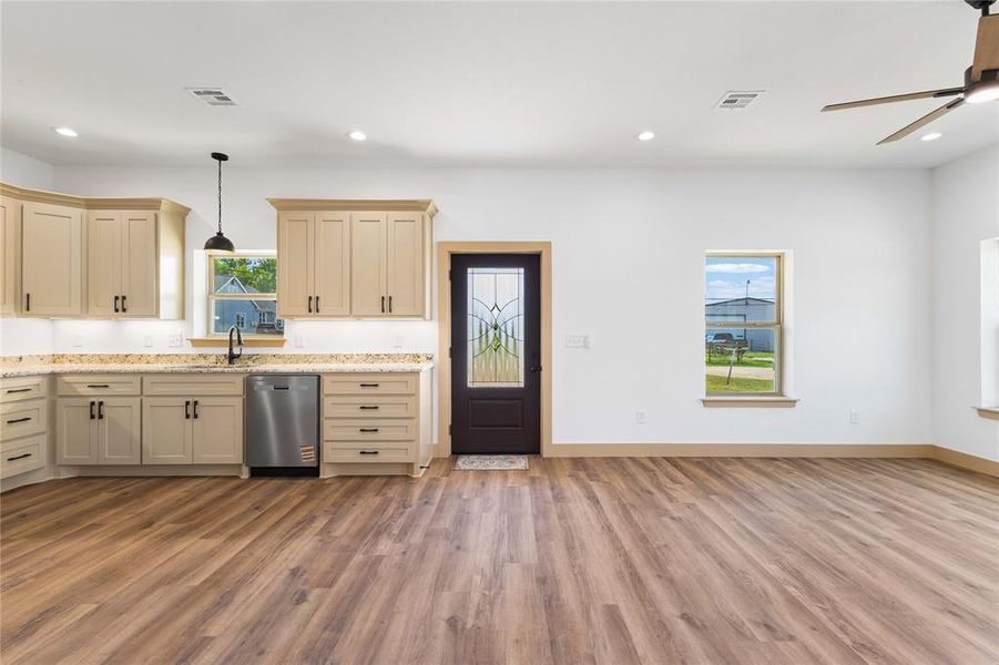 Kitchen featuring open floor plan, recessed lighting, cream cabinetry, light wood-style floors, and stainless steel appliances