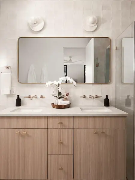 A well-lit primary bathroom features a double vanity with ample storage and a frameless mirror reflecting the natural light. A well-lit primary bathroom features a double vanity with ample storage and a frameless mirror reflecting the natural light.
