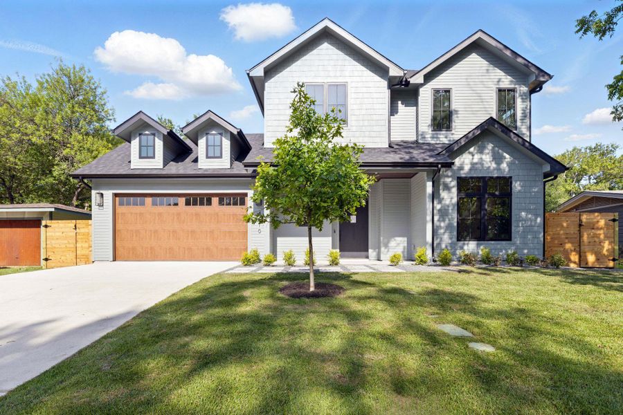 View of front of house featuring concrete driveway, an attached garage, and a shingled roof