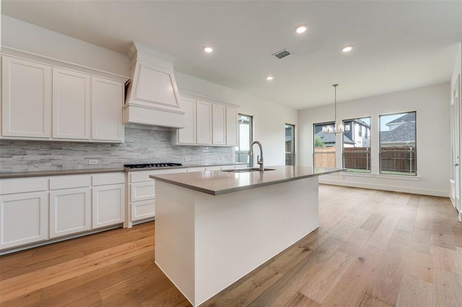 Kitchen with white cabinetry, sink, and a wealth of natural light