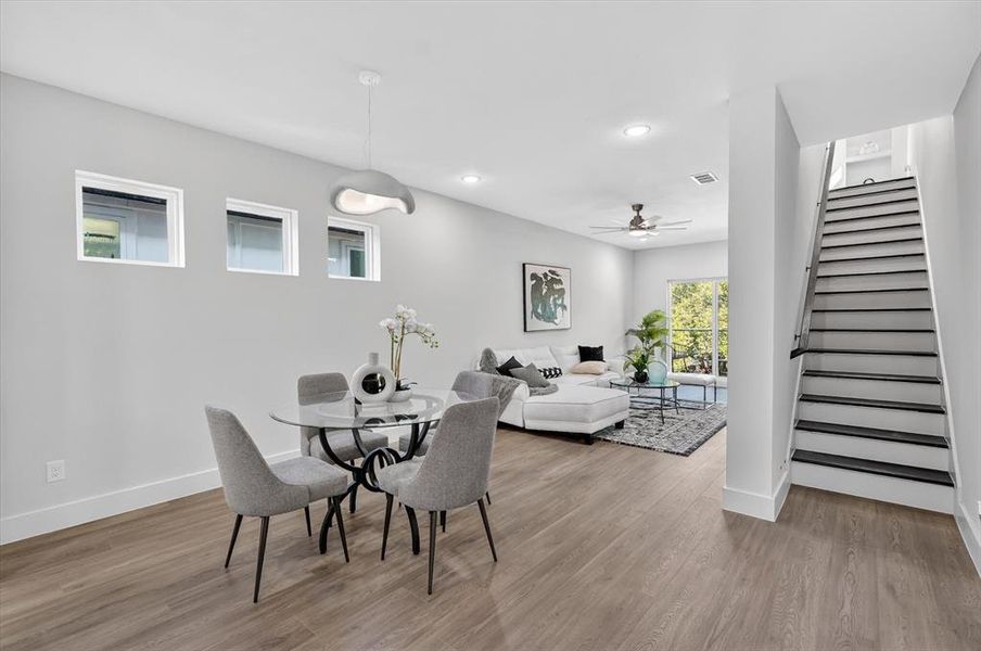 Open-concept living area featuring wood-finish flooring, recessed lighting, and a modern ceiling fan