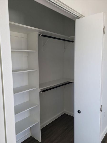 Integrated shelving and dual hanging rods create a highly organized storage area.